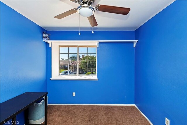 carpeted empty room with baseboards and a ceiling fan