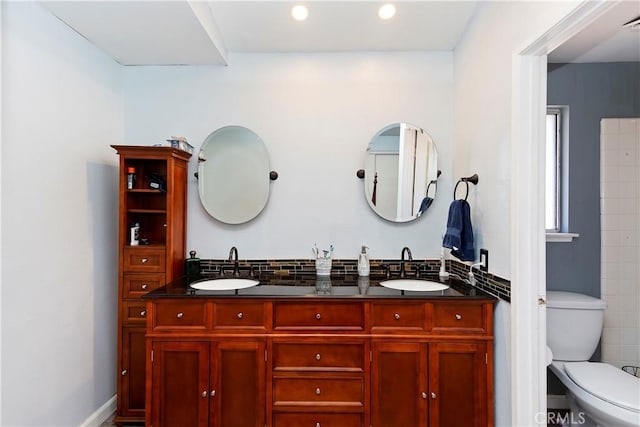 full bathroom with a sink, tasteful backsplash, toilet, and double vanity