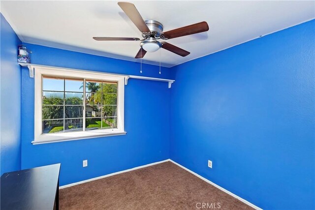 unfurnished room featuring a ceiling fan, carpet, and baseboards