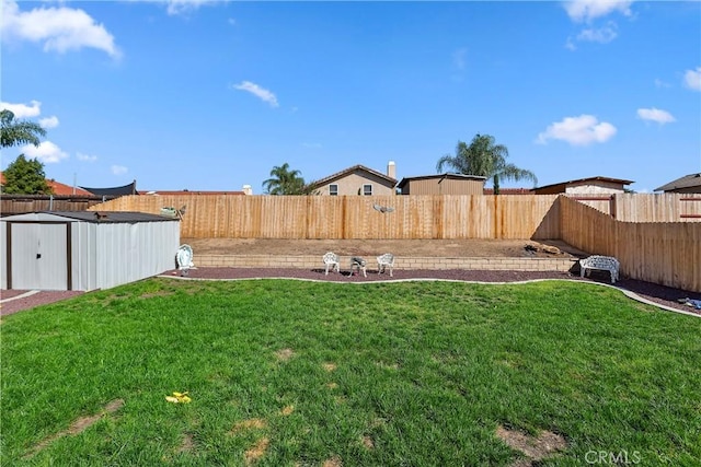 view of yard featuring an outdoor structure, a storage unit, and a fenced backyard