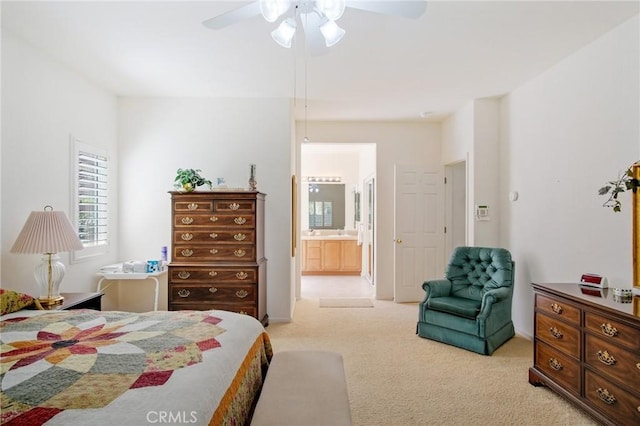 bedroom with ensuite bath, a ceiling fan, and light colored carpet