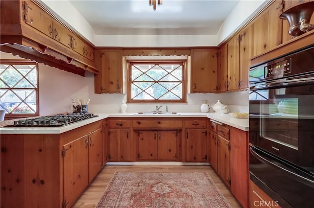 kitchen featuring a warming drawer, light countertops, gas stovetop, and brown cabinets