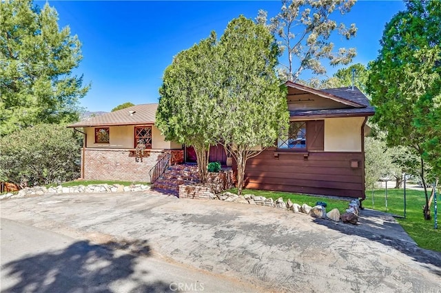 view of front of house featuring brick siding and stucco siding