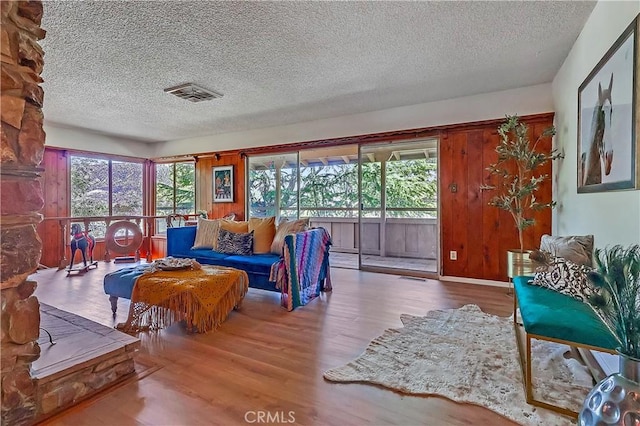 sitting room with a healthy amount of sunlight, visible vents, and wood finished floors