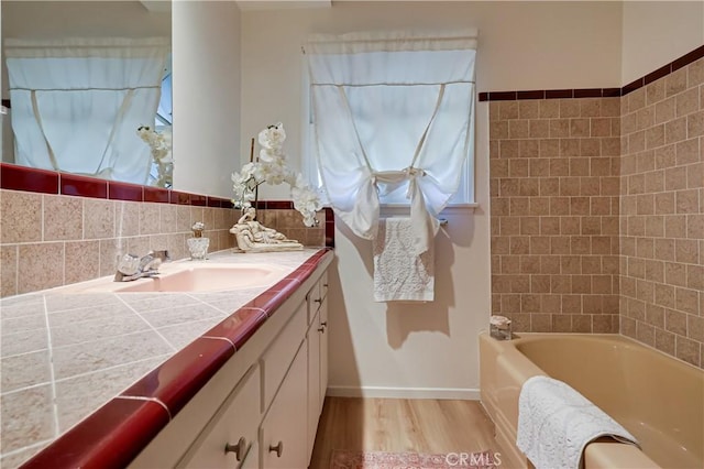 full bathroom with vanity, baseboards, and wood finished floors