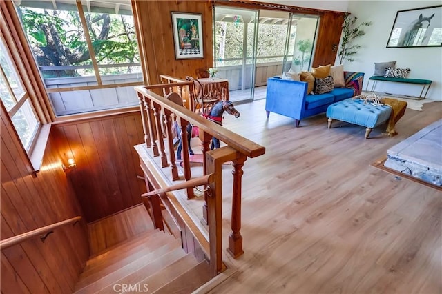 staircase with wood walls and wood finished floors