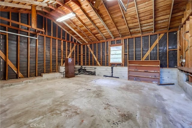 misc room with vaulted ceiling and unfinished concrete flooring