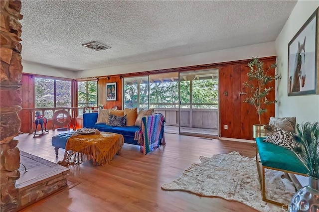 living area featuring plenty of natural light, visible vents, and wood finished floors