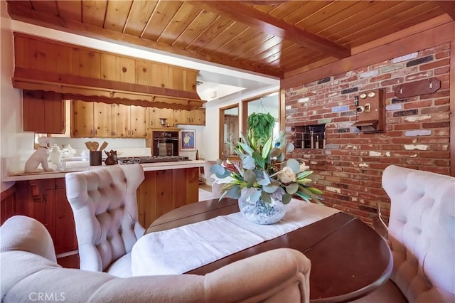 dining room with beam ceiling, wooden ceiling, and brick wall