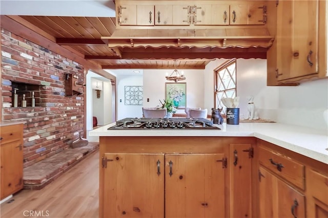 kitchen featuring wooden ceiling, a peninsula, gas stovetop, light wood-style floors, and light countertops