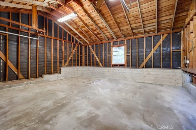 miscellaneous room with concrete flooring and lofted ceiling