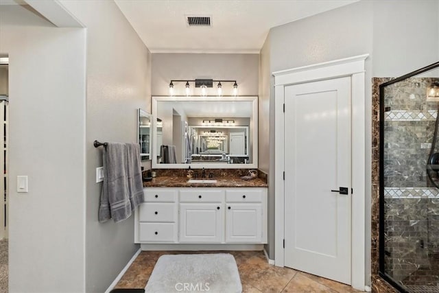 bathroom with a shower stall, visible vents, and vanity