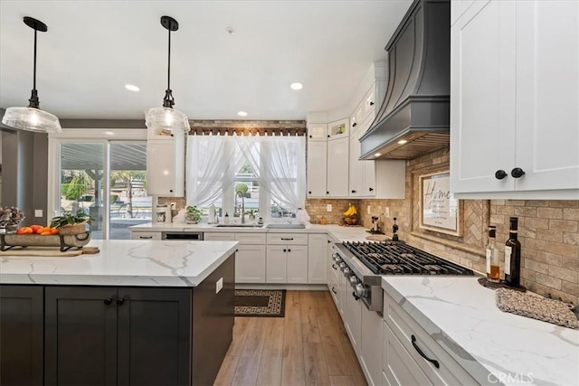 kitchen featuring stainless steel gas cooktop, a sink, white cabinets, backsplash, and custom exhaust hood