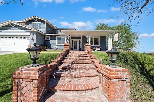 view of front of home with a garage, covered porch, driveway, and a front lawn