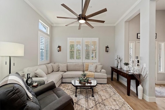 living room featuring light wood-style floors, baseboards, and crown molding