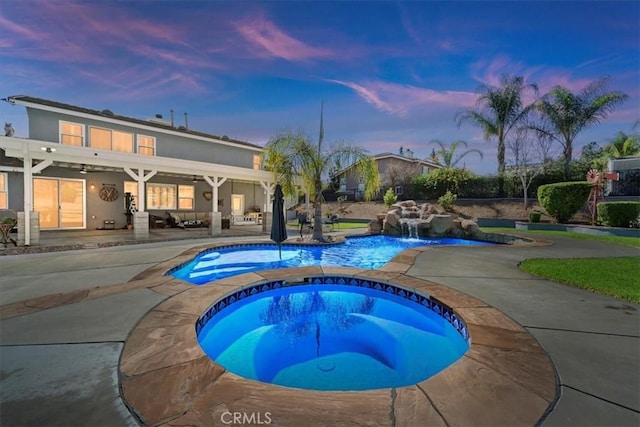 pool with a patio area and an in ground hot tub