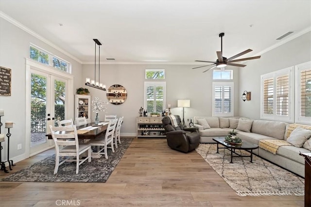 living room featuring wood finished floors, visible vents, and crown molding