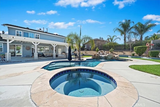 pool with an in ground hot tub and a patio area