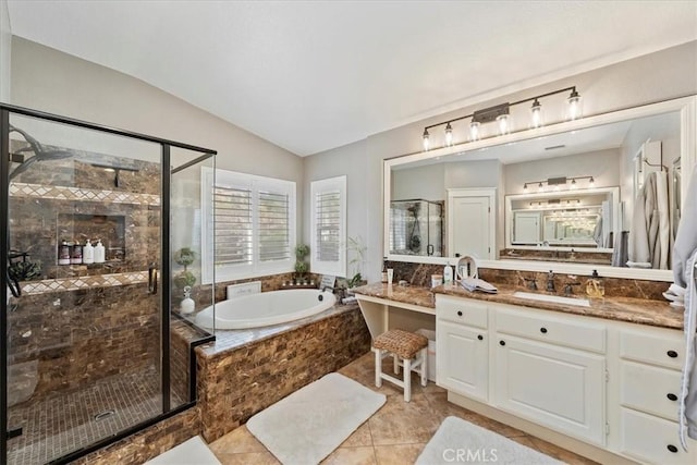 full bathroom featuring tile patterned flooring, a garden tub, vanity, vaulted ceiling, and a stall shower