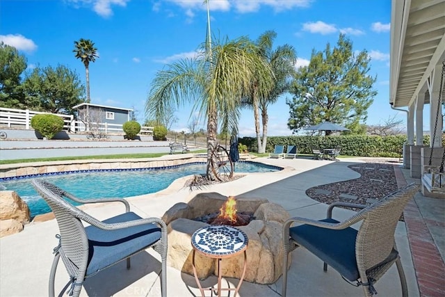 view of swimming pool featuring a fire pit, a patio area, fence, and a fenced in pool