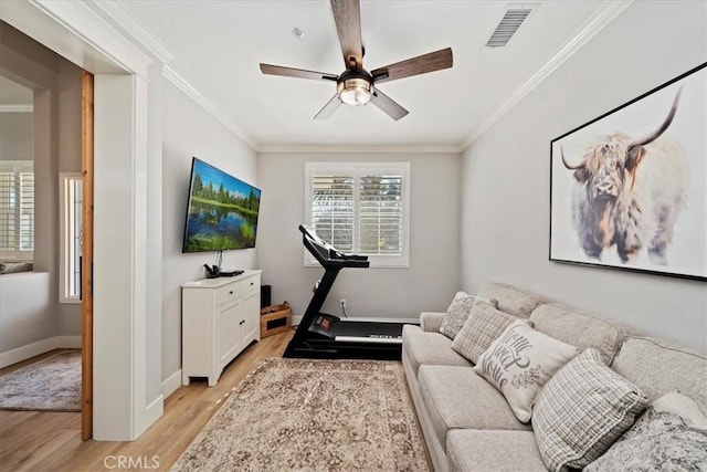 interior space featuring light wood-style floors, visible vents, crown molding, and ceiling fan