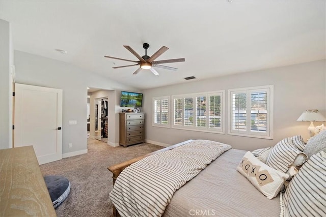 carpeted bedroom featuring a closet, visible vents, a spacious closet, vaulted ceiling, and baseboards