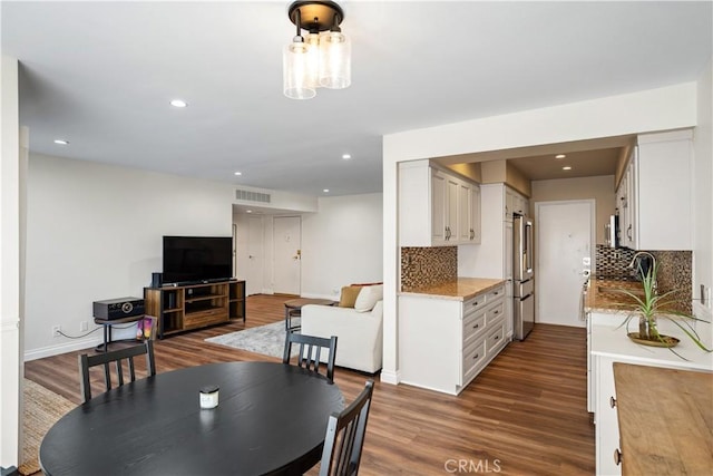 dining room with baseboards, wood finished floors, visible vents, and recessed lighting