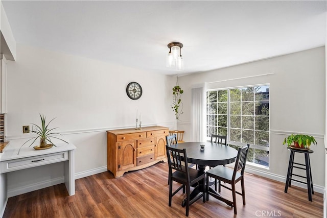 dining space with baseboards and wood finished floors