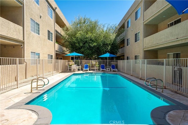 pool featuring a patio area and fence