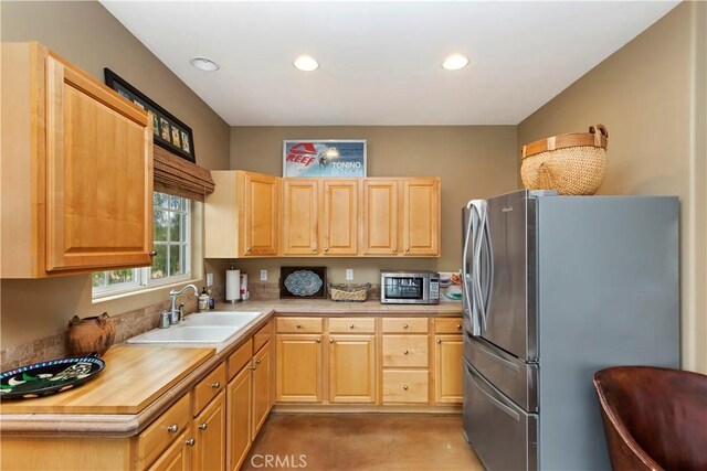 kitchen featuring a sink, stainless steel appliances, recessed lighting, and light brown cabinetry