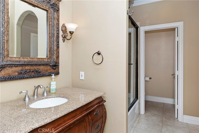 full bathroom featuring vanity, baseboards, tile patterned flooring, and shower / bath combination with glass door