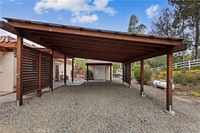 view of parking / parking lot with a carport and fence