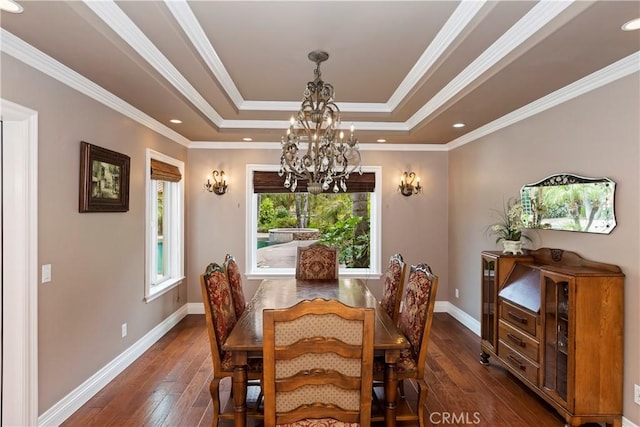 dining area featuring crown molding, a raised ceiling, baseboards, and hardwood / wood-style floors