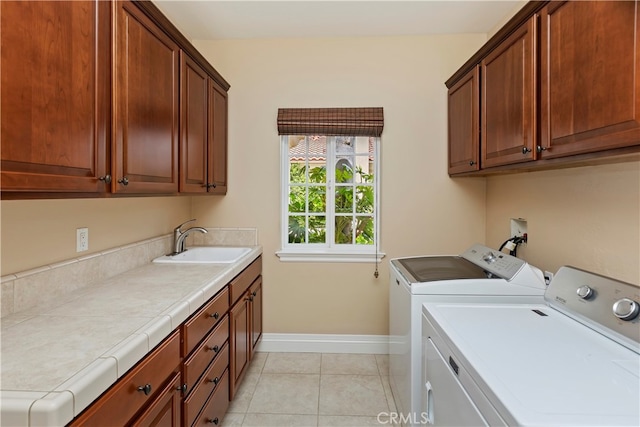 laundry room with washer and dryer, a sink, cabinet space, light tile patterned floors, and baseboards