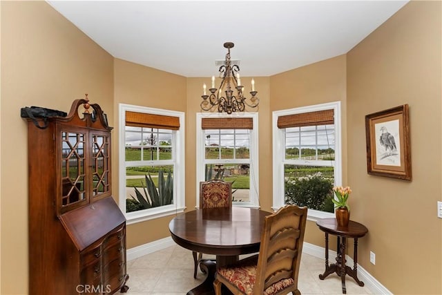 dining area featuring a notable chandelier, baseboards, and light tile patterned floors