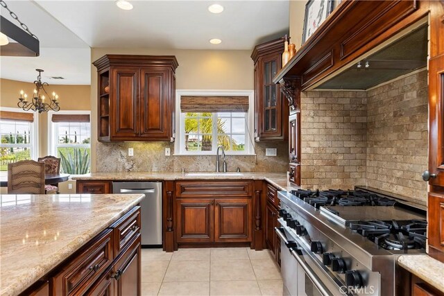 kitchen with premium range hood, a sink, tasteful backsplash, appliances with stainless steel finishes, and light stone countertops