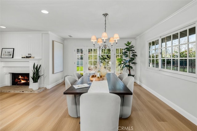 2851 Catalpa St, Newport Beach, CA 92660 - dining room featuring a brick fireplace, crown molding, light wood-style flooring, and baseboards