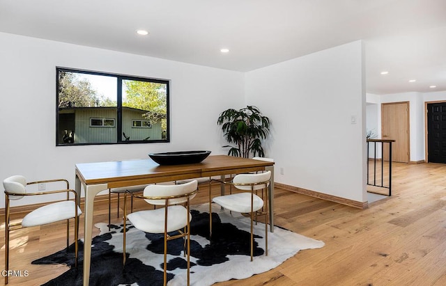 dining area with baseboards, light wood-type flooring, and recessed lighting