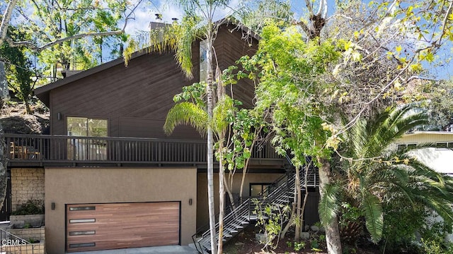 exterior space featuring stucco siding, an attached garage, and stairs