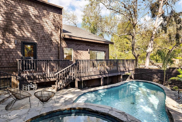 view of pool featuring a patio area, a wooden deck, fence, and an in ground hot tub