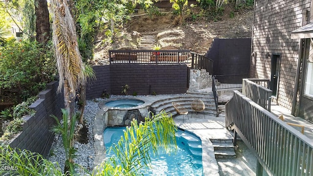 view of swimming pool with a pool with connected hot tub and stairway