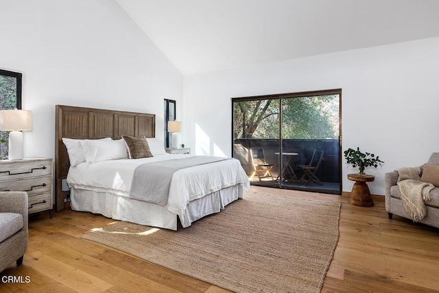 bedroom with high vaulted ceiling, light wood-type flooring, and access to exterior