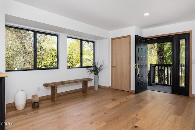 entryway with a wealth of natural light, light wood-type flooring, baseboards, and recessed lighting