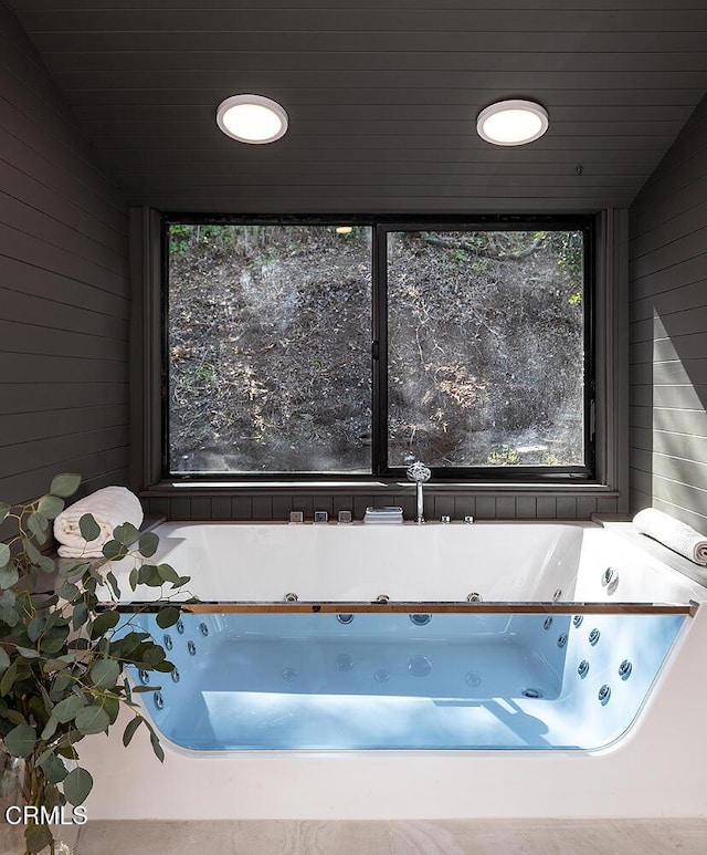 full bathroom with a whirlpool tub, wood walls, and wooden ceiling