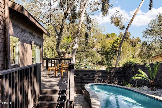 view of swimming pool featuring a fenced backyard, a fenced in pool, and a wooden deck