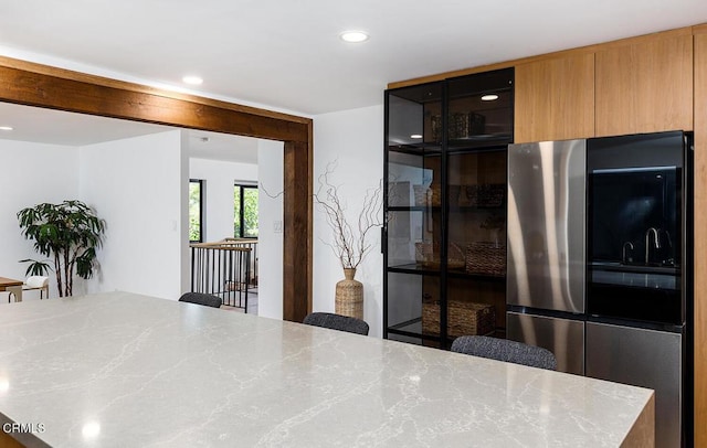 kitchen with recessed lighting, modern cabinets, smart refrigerator, and light stone countertops