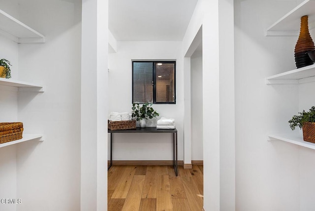 hallway featuring baseboards and wood finished floors