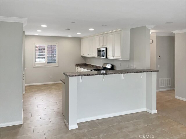 3434 Presidio Ln, Perris, CA 92570 - kitchen with visible vents, a peninsula, stainless steel microwave, range with gas cooktop, and a kitchen breakfast bar