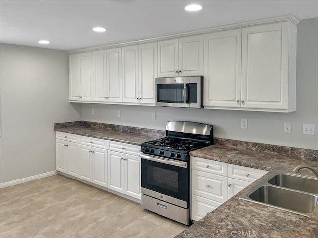 3434 Presidio Ln, Perris, CA 92570 - kitchen with white cabinetry, dark countertops, a sink, and stainless steel appliances