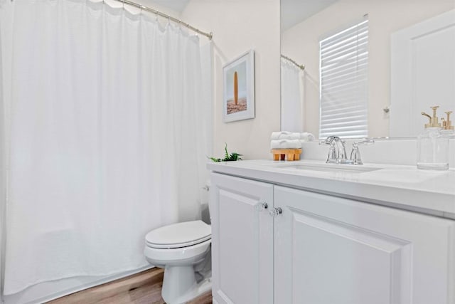 full bathroom with toilet, a shower with curtain, wood finished floors, and vanity